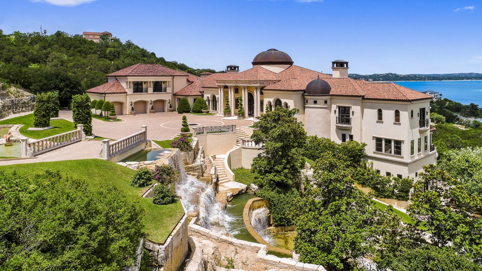 Aerial view of a Mediterranean estate above Lake Travis with terraced waterfalls