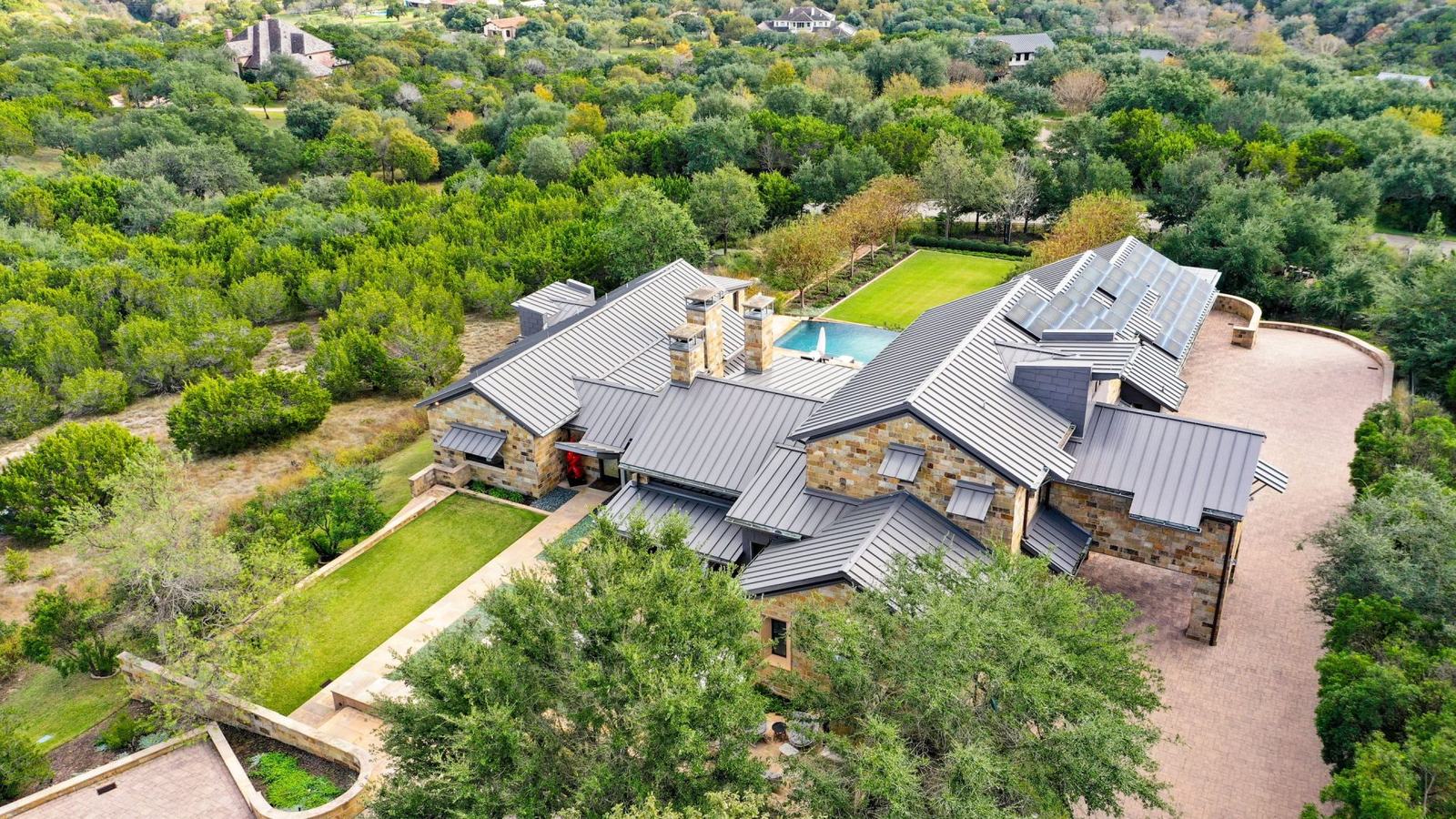 Ranch-style home on a wooded ridge from the air