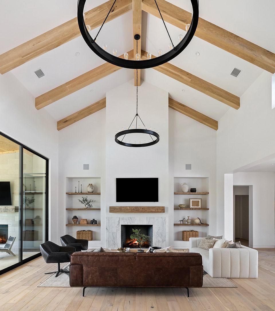 Living room with a limestone fireplace and beamed ceiling