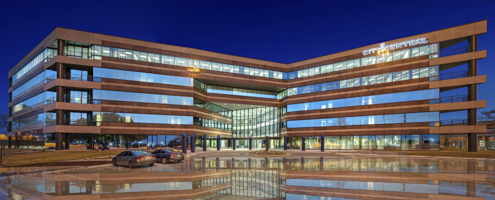 Glass office building reflected at dusk