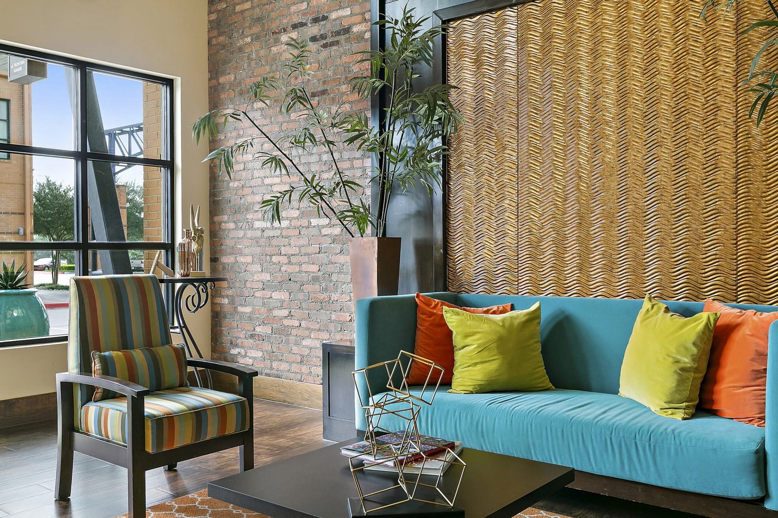 Lounge with turquoise sofa and brick feature wall