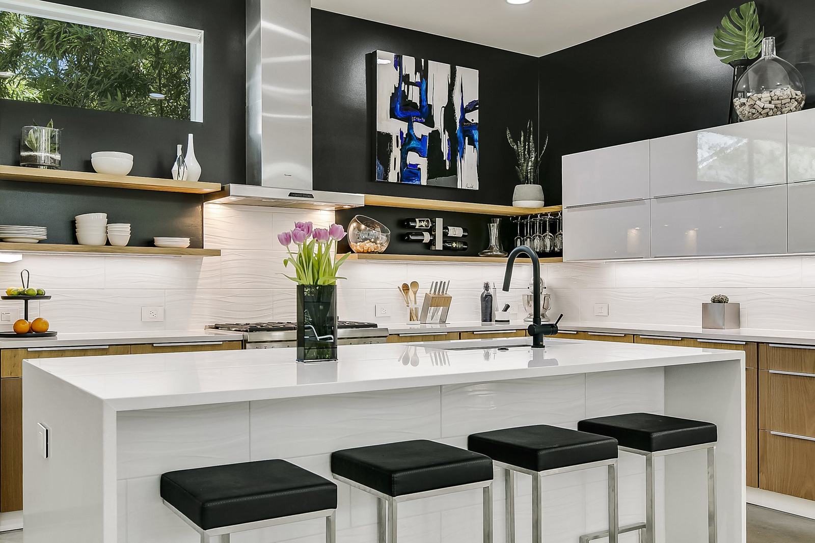 Kitchen with dark cabinetry and a white island