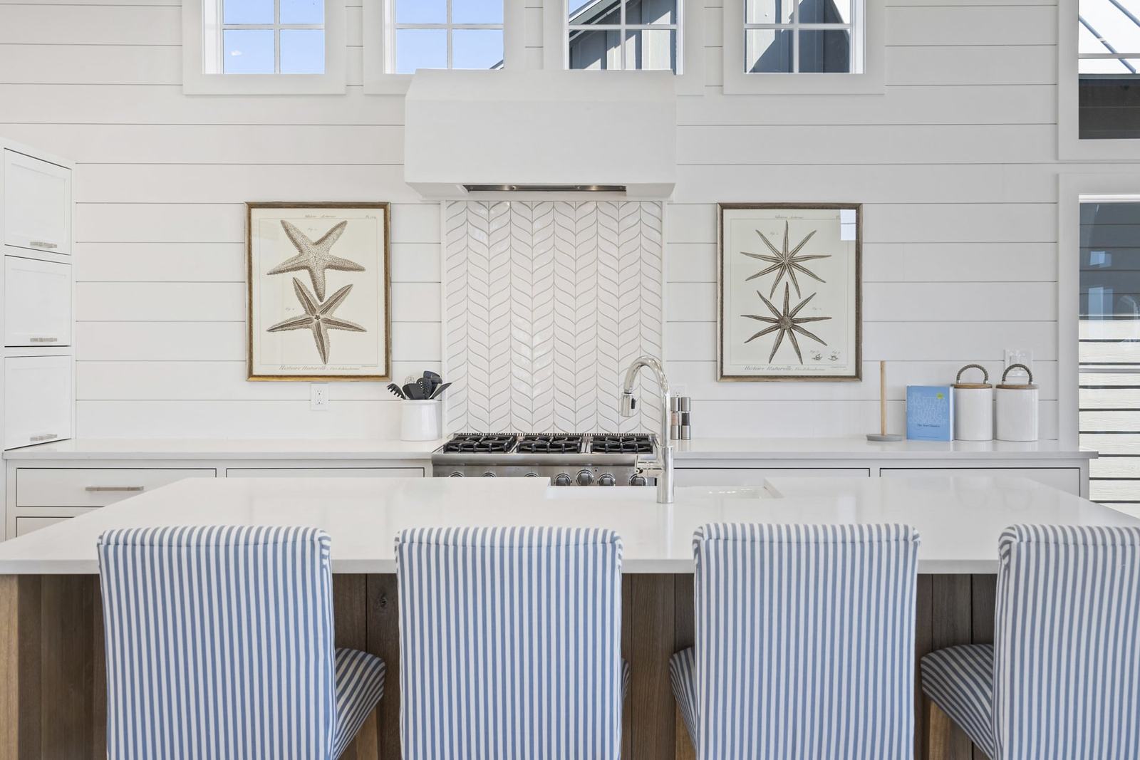 White kitchen with a vaulted ceiling and exposed beams