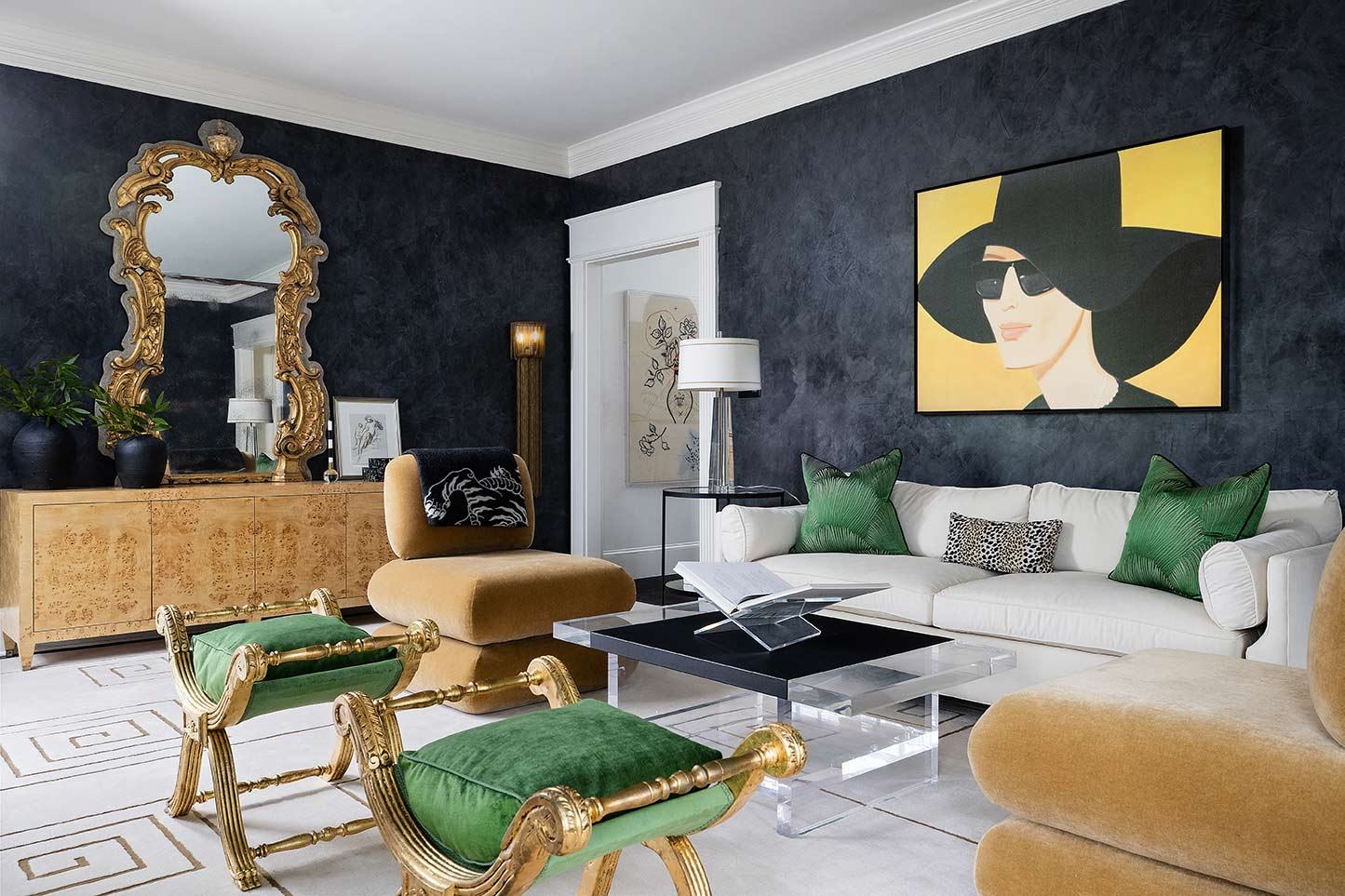 Lounge with a black accent wall and green velvet chairs
